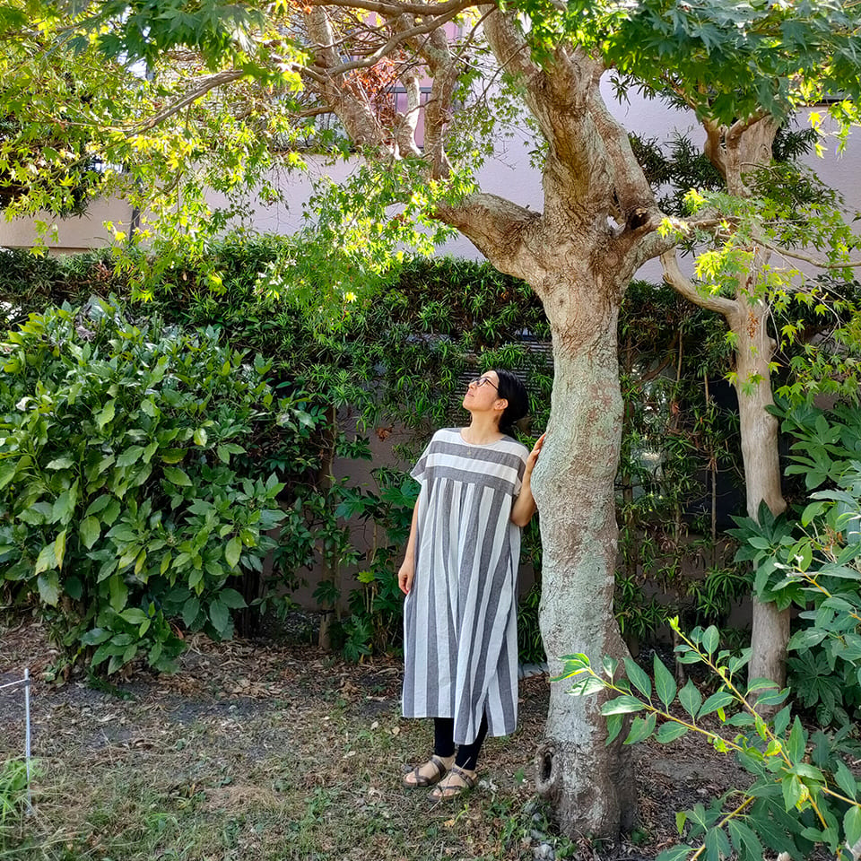 写真：楓の樹の下に立つ micono さん